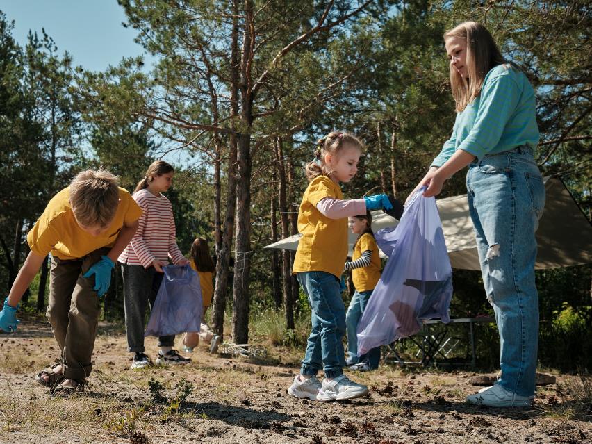 Børn samler skrald i en skov