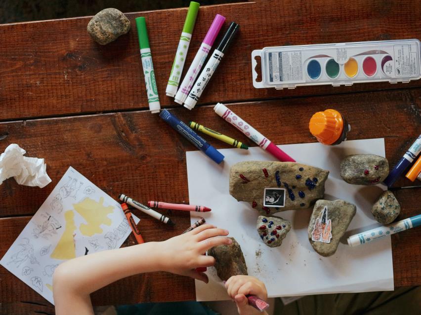 Barn tegner på sten med forskellige farver